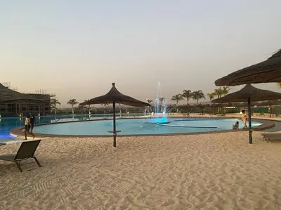a large swimming pool with umbrellas on a beach at TK’s Penthouse - The Blyde in Pretoria