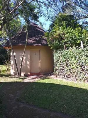 a small house with a thatched roof at Crocodile Nest B&B in Nelspruit