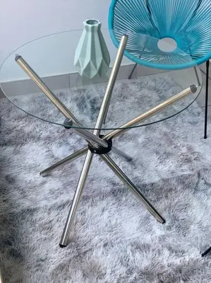 a glass table with a blue chair on a rug at The Blyde -Ender137 in Pretoria
