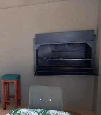 a room with a chair and a shelf on the wall at Ebenhaeser overnight accomodation in Bela-Bela
