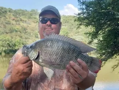 a man holding a large fish in his hands at Ebenhaeser overnight accomodation in Bela-Bela