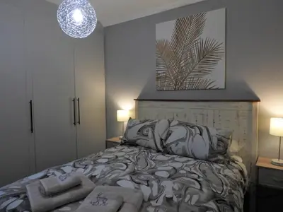 a bedroom with a bed and a pendant light at Locust Retreat in Marloth Park in Marloth Park
