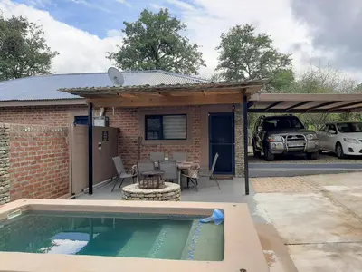 a house with a swimming pool next to a building at Locust Retreat in Marloth Park in Marloth Park