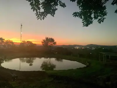 a small pond with a sunset in the background at Hazyview Accommodation, Bon Repose Cottage 1 in Hazyview