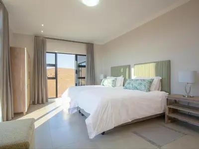 a bedroom with a large bed and a large window at Highland Gate Ferox Creek in Dullstroom