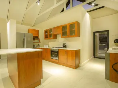 a large kitchen with wooden cabinets and stainless steel appliances at Highland Gate Ferox Creek in Dullstroom