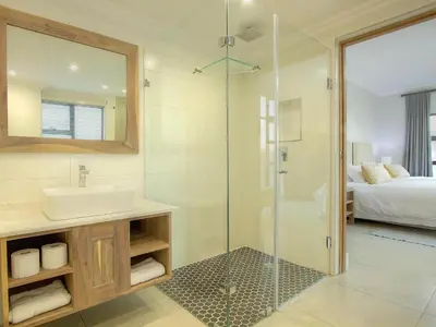 a bathroom with a sink and a glass shower at Highland Gate Ferox Creek in Dullstroom