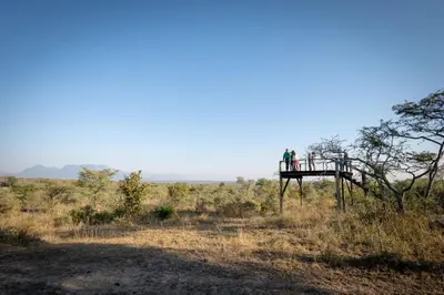 two people standing on a platform in the middle of a field at Sunbirds Oasis Lodge in Hoedspruit