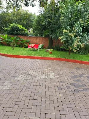 a patio with a red table and chairs in a yard at G On M Guest House in Pretoria