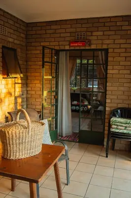 a room with a table and a chair and a door at Mackers Self Catering Cottages in Hazyview