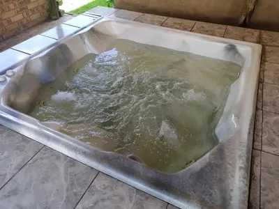 a bath tub filled with water on a tiled floor at FRANCHISE BENONI GUEST HOUSE in Benoni