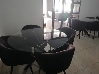 a glass table and chairs in a room at FRANCHISE BENONI GUEST HOUSE in Benoni