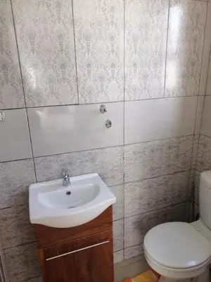 a bathroom with a sink and a toilet at FRANCHISE BENONI GUEST HOUSE in Benoni