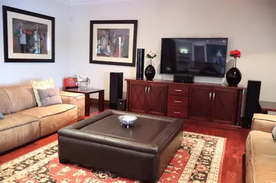 a living room with a couch and a tv at The Sanctum in Hartbeespoort