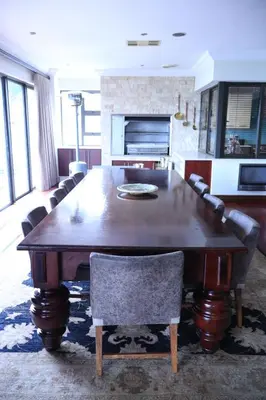 a dining room with a large wooden table and chairs at The Sanctum in Hartbeespoort