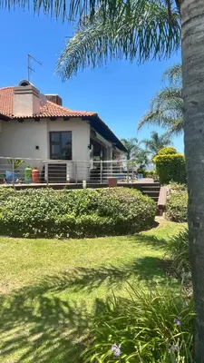 a house with a palm tree in the yard at The Sanctum in Hartbeespoort
