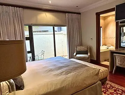 a bedroom with a large bed and a balcony at The Sanctum in Hartbeespoort