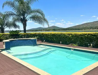 a swimming pool in a yard with a palm tree at The Sanctum in Hartbeespoort