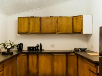 a kitchen with wooden cabinets and a white refrigerator at Cussonia Cottage in Haenertsburg