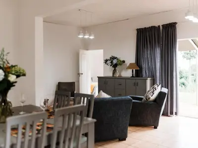 a living room with a couch and a table at Cussonia Cottage in Haenertsburg