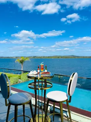 a table and chairs on a balcony with a view of the water at Nandoni Waterfront Resort in Thohoyandou