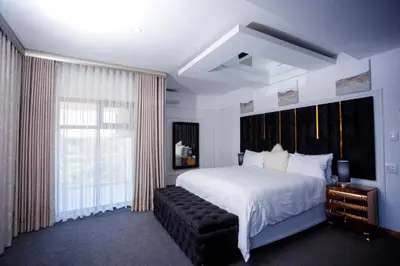 a bedroom with a large bed and a large window at Nandoni Waterfront Resort in Thohoyandou