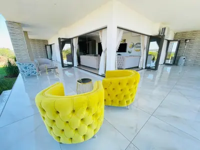 a room with two yellow chairs and a living room at Nandoni Waterfront Resort in Thohoyandou