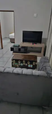a living room with a table with a television and a couch at Ribeng la Noka Conference and Leisure Center in Ga-Ramokadi-kadi