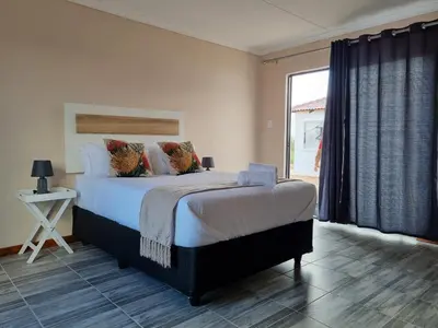 a bedroom with a large bed and a large window at Ribeng la Noka Conference and Leisure Center in Ga-Ramokadi-kadi