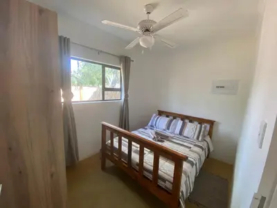 a bedroom with a bed and a ceiling fan at Vlakkieskraal Farmstay - BushBaby House in Bela-Bela