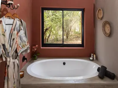 a large bath tub in a bathroom with a window at Muunga Bush Lodge & Spa in Hoedspruit