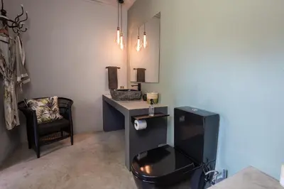 a bathroom with a sink and a desk with a chair at Muunga Bush Lodge & Spa in Hoedspruit