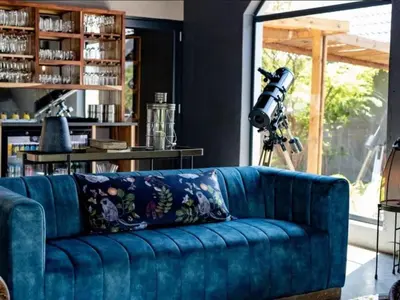 a blue couch in a living room with a camera at Muunga Bush Lodge & Spa in Hoedspruit