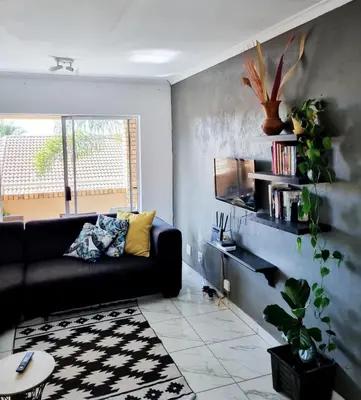 a living room with a black couch and a window at Home away from home in Centurion