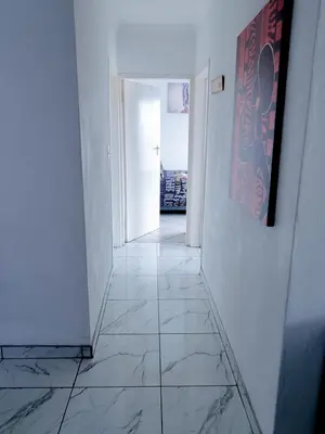 a hallway with white walls and a tile floor at Home away from home in Centurion