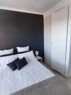 a bedroom with a large white bed with two pillows at Home away from home in Centurion