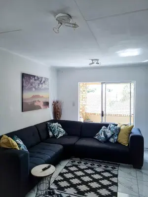 a living room with a blue couch and a table at Home away from home in Centurion