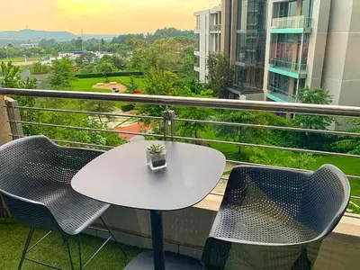 a white table and chairs on a balcony at Menlyn Maine Residences - Superior king - Paris apartment in Pretoria