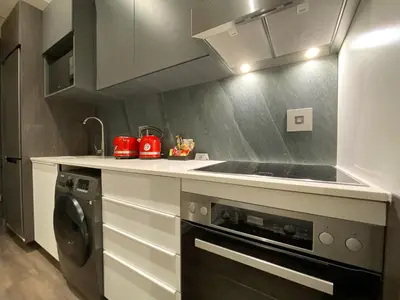 a kitchen with a sink and a washing machine at Menlyn Maine Residences - Superior king - Paris apartment in Pretoria