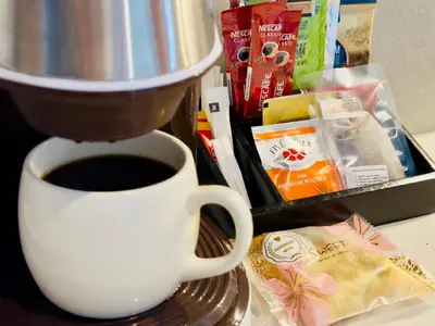 a cup of coffee sitting on a table next to a mixer at Menlyn Maine Residences - Superior king - Paris apartment in Pretoria