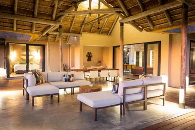 a living room with white chairs and a table at Villa Tall Horse - Zandspruit Bush and Aero Estate in Hoedspruit