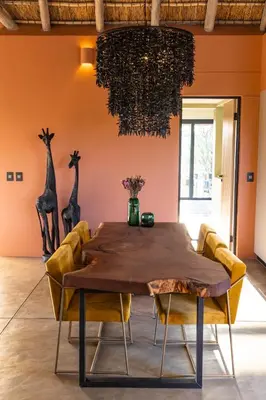 a dining room with a wooden table and chairs at Villa Tall Horse - Zandspruit Bush and Aero Estate in Hoedspruit