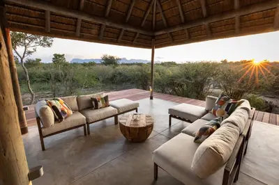 a living room with couches and a view of the wilderness at Villa Tall Horse - Zandspruit Bush and Aero Estate in Hoedspruit