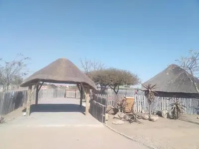 aosure at a zoo with a fence and a thatched shelter at Unique Overnight Polokwane in Polokwane