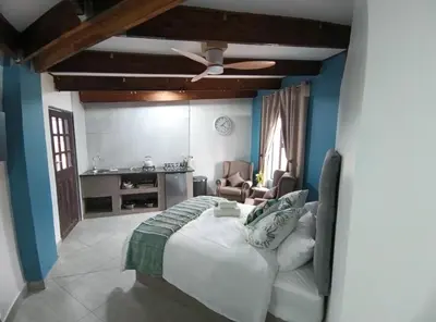 a bedroom with a bed with a ceiling fan at Unique Overnight Polokwane in Polokwane