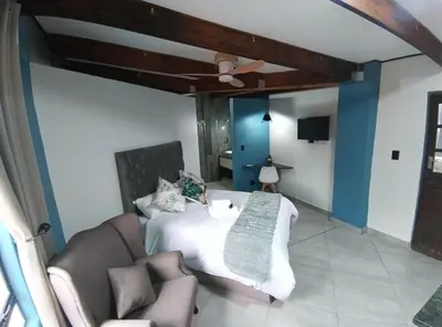 a bedroom with a bed and a couch at Unique Overnight Polokwane in Polokwane