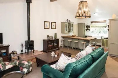 a living room with a couch and a table at Willow Cottage in Dullstroom