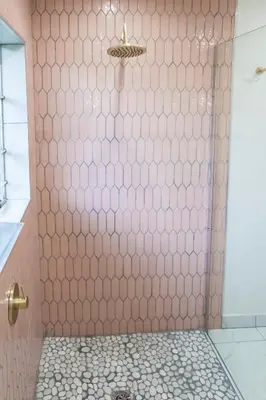 a shower with a pink tiled wall at Willow Cottage in Dullstroom