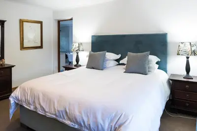 a bedroom with a large white bed with pillows at Willow Cottage in Dullstroom