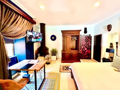 a bedroom with a bed and a desk and a tv at Forty 4 On Hoog in Polokwane